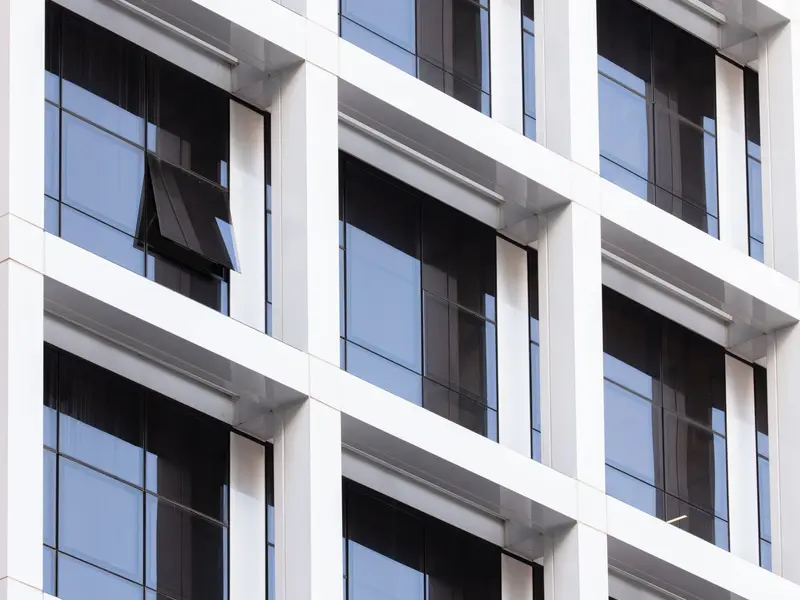 Fasada moderne zgrade s tamnim aluminijskim prozorima u pravilnom nizu